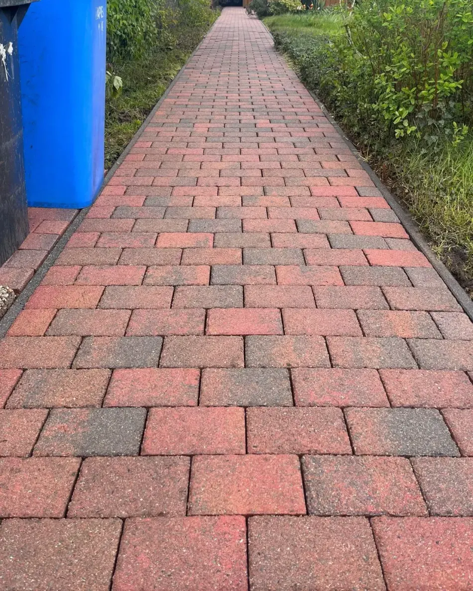 Derselbe Gehweg nachher: gereinigtes Pflaster in der ursprünglichen roten Farbe