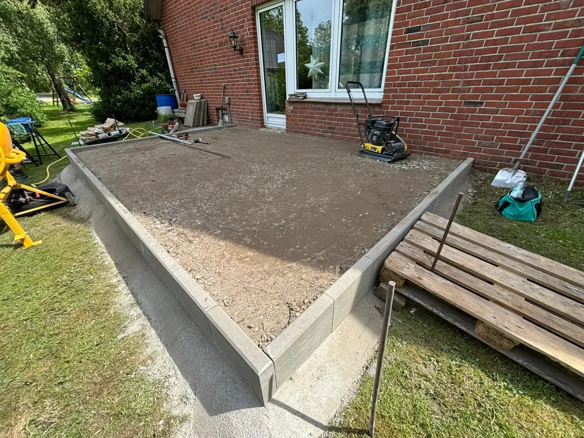 Dieselbe Terrasse vorher: verdichteter Unterbau mit gesetzter Randeinfassung und Rüttelplatte