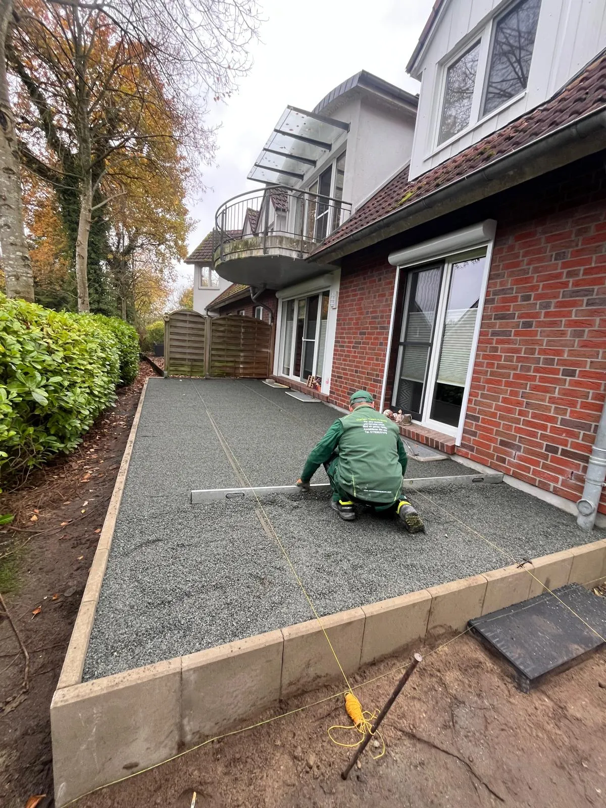 Mitarbeiter von Garten Team Krause beim präzisen Abziehen des Terrassen-Splittbetts